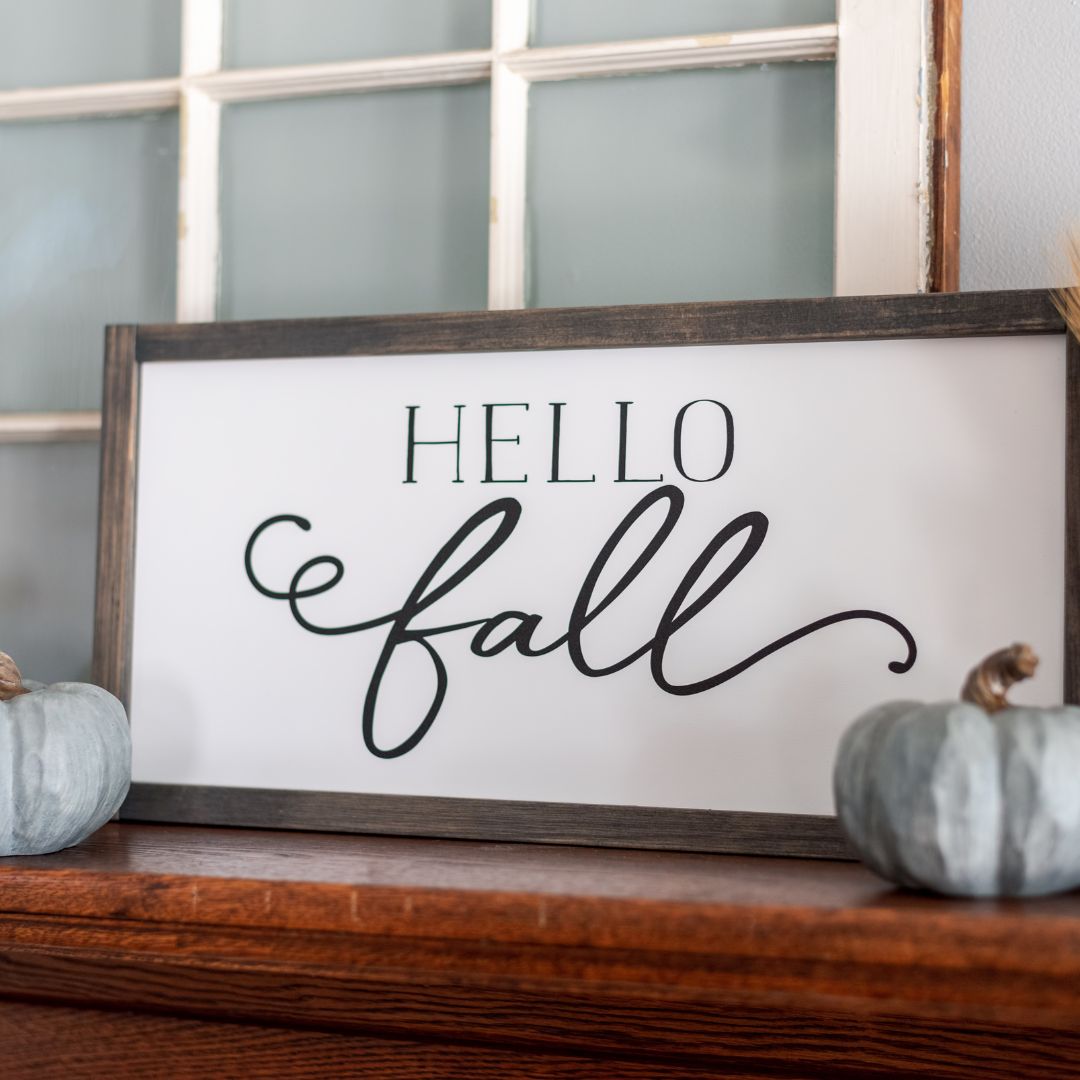 Hello Fall wall art on table with pumpkins with a blue wall behind